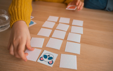 des mains d'enfants qui jouent à un jeu de cartes