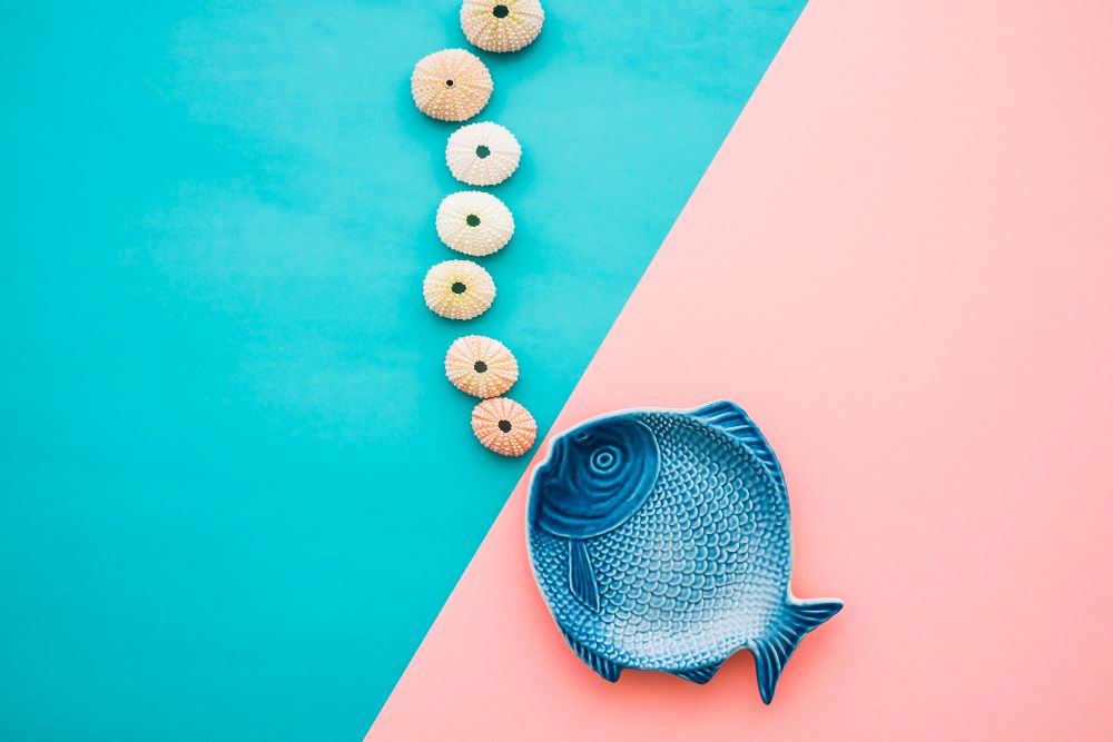 un poisson en ceramique sur un fond bleu et rose
